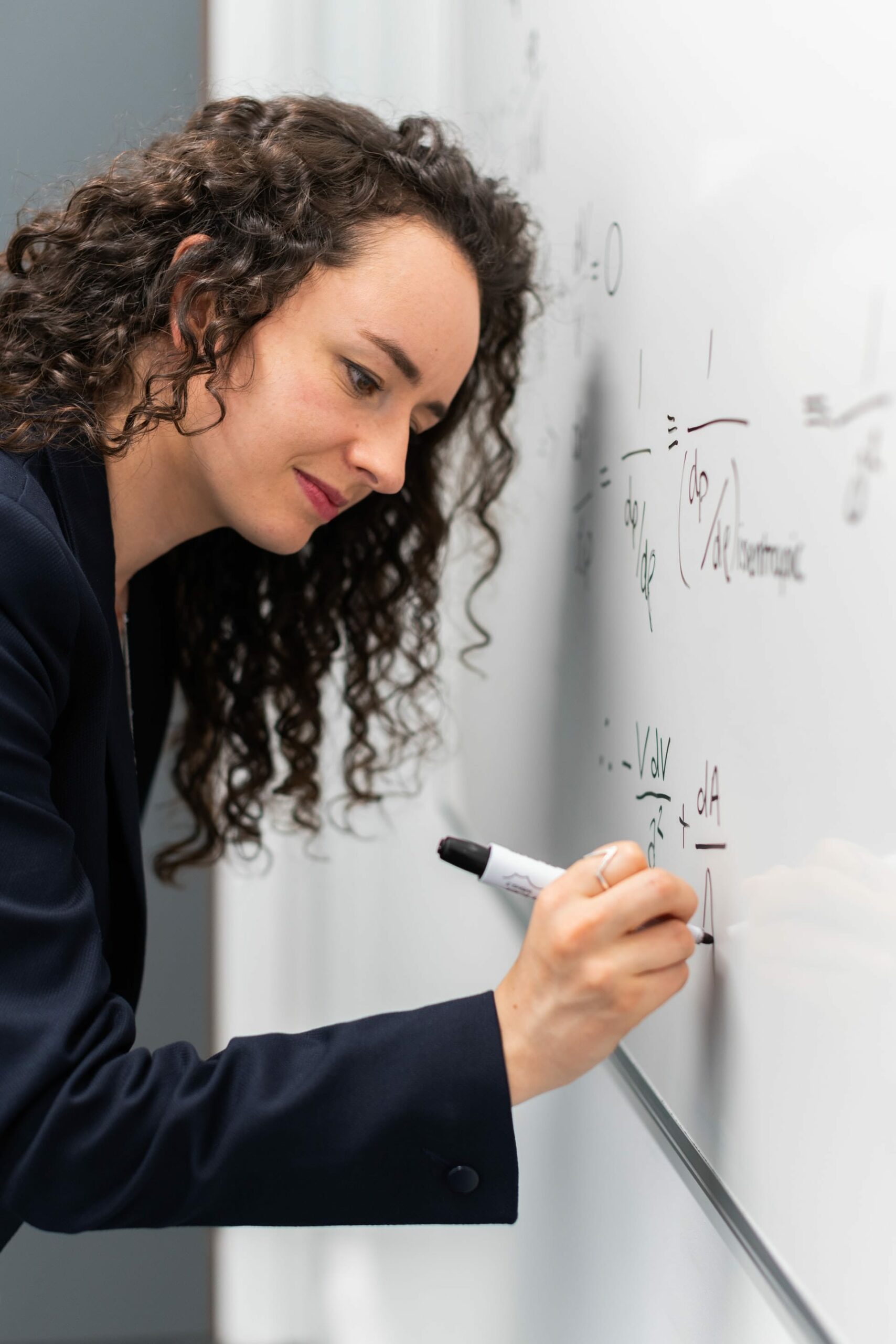 professeur écrivant des maths au tableau