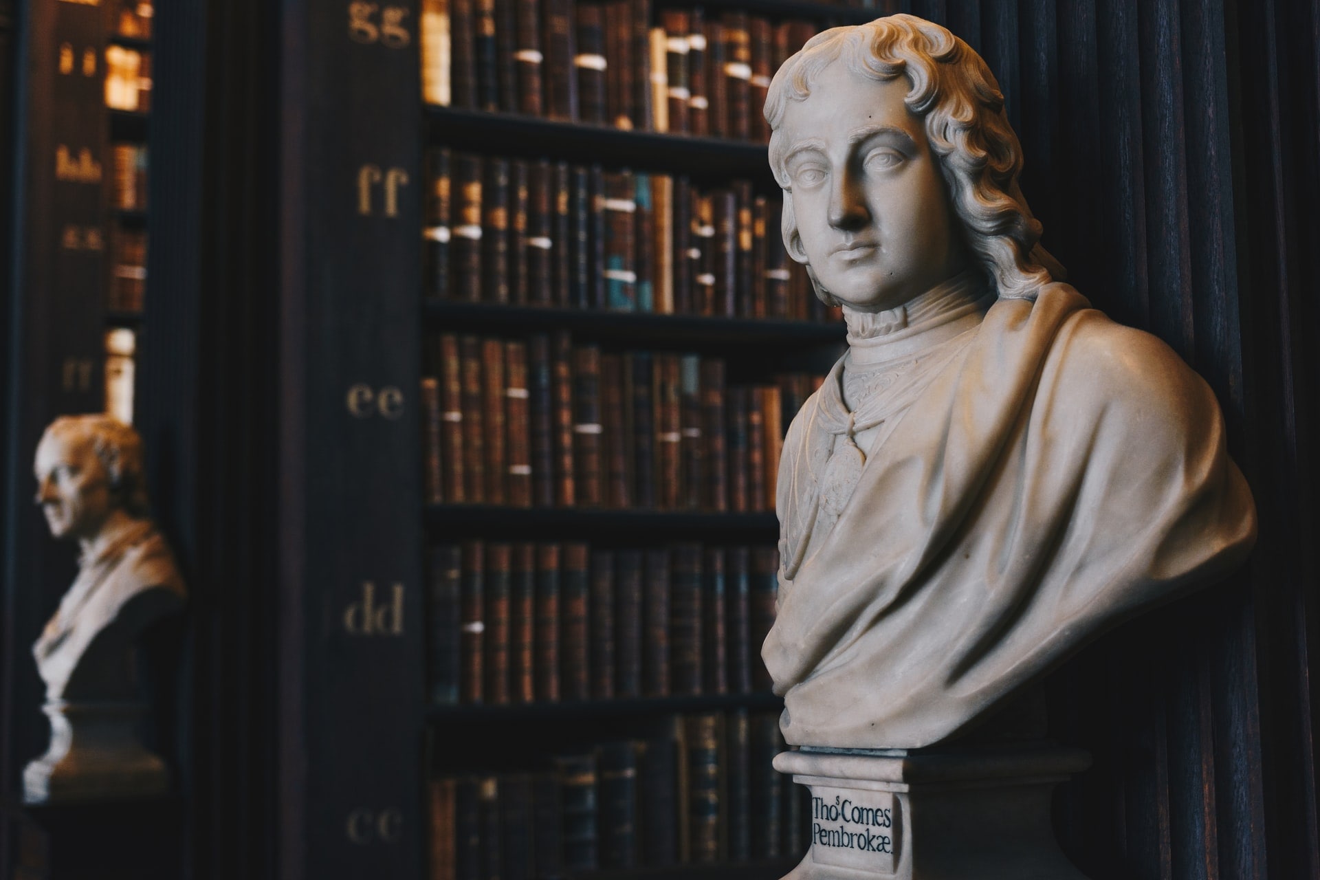 bibliothèque avec des statues de philosophe