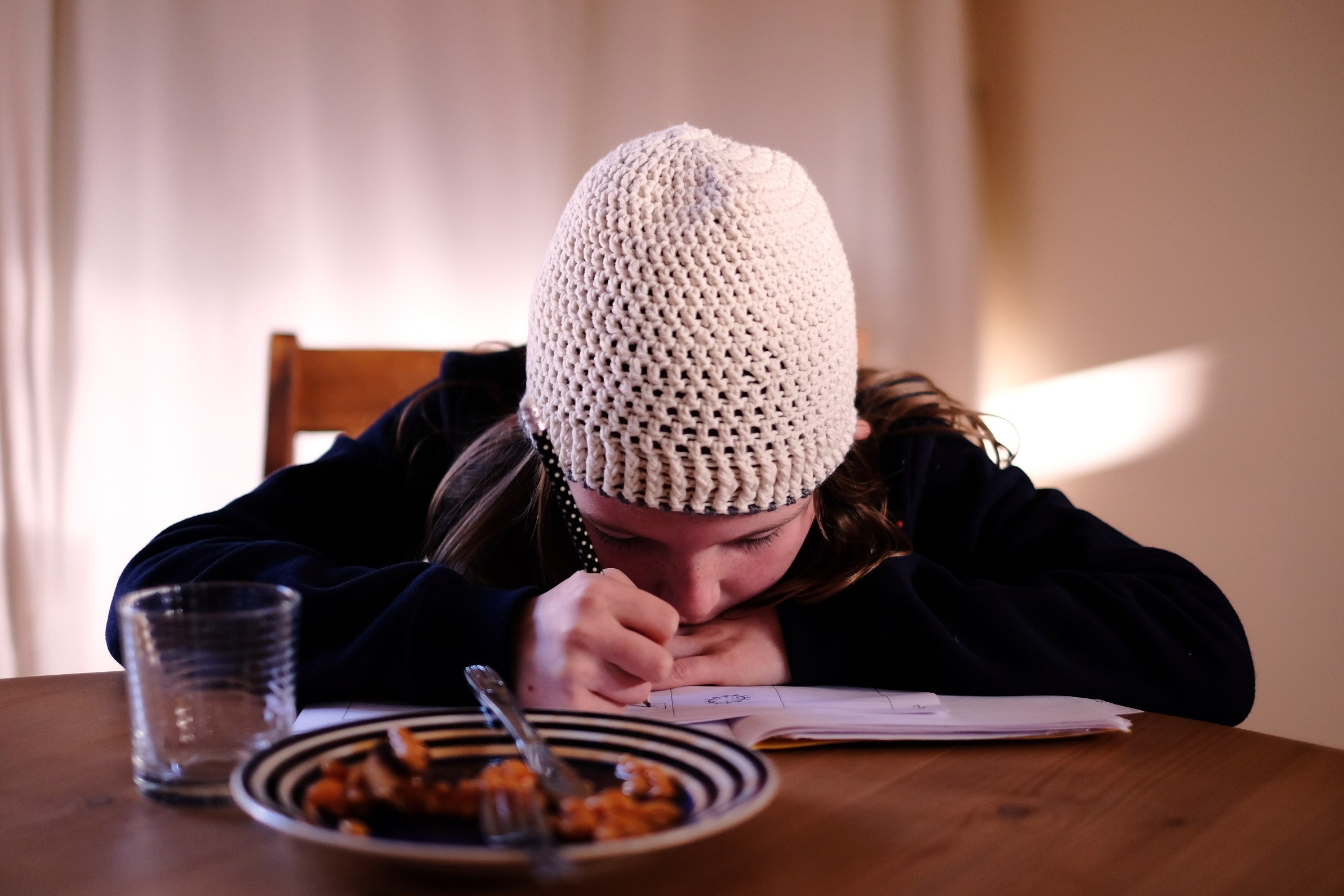 enfant faisant ses devoirs de français devant son goûté