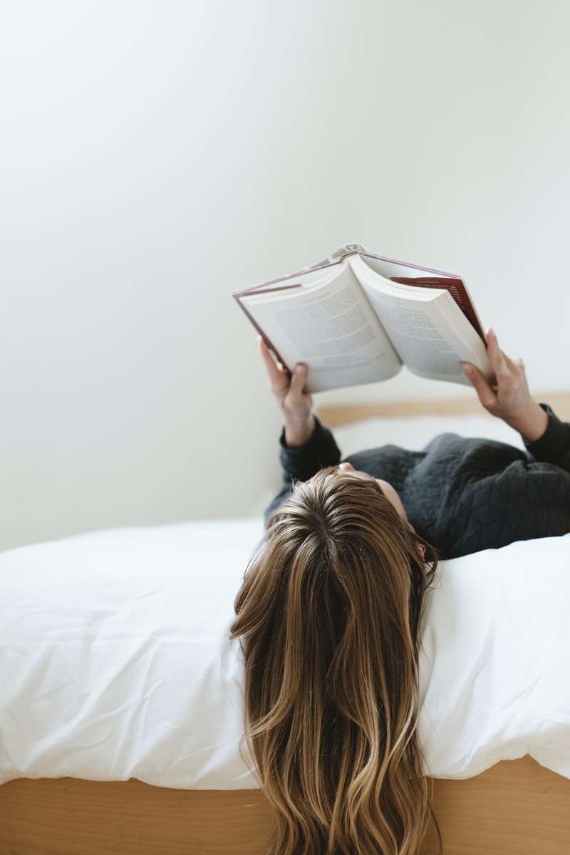 jeune fille lisant un livre dans son lit