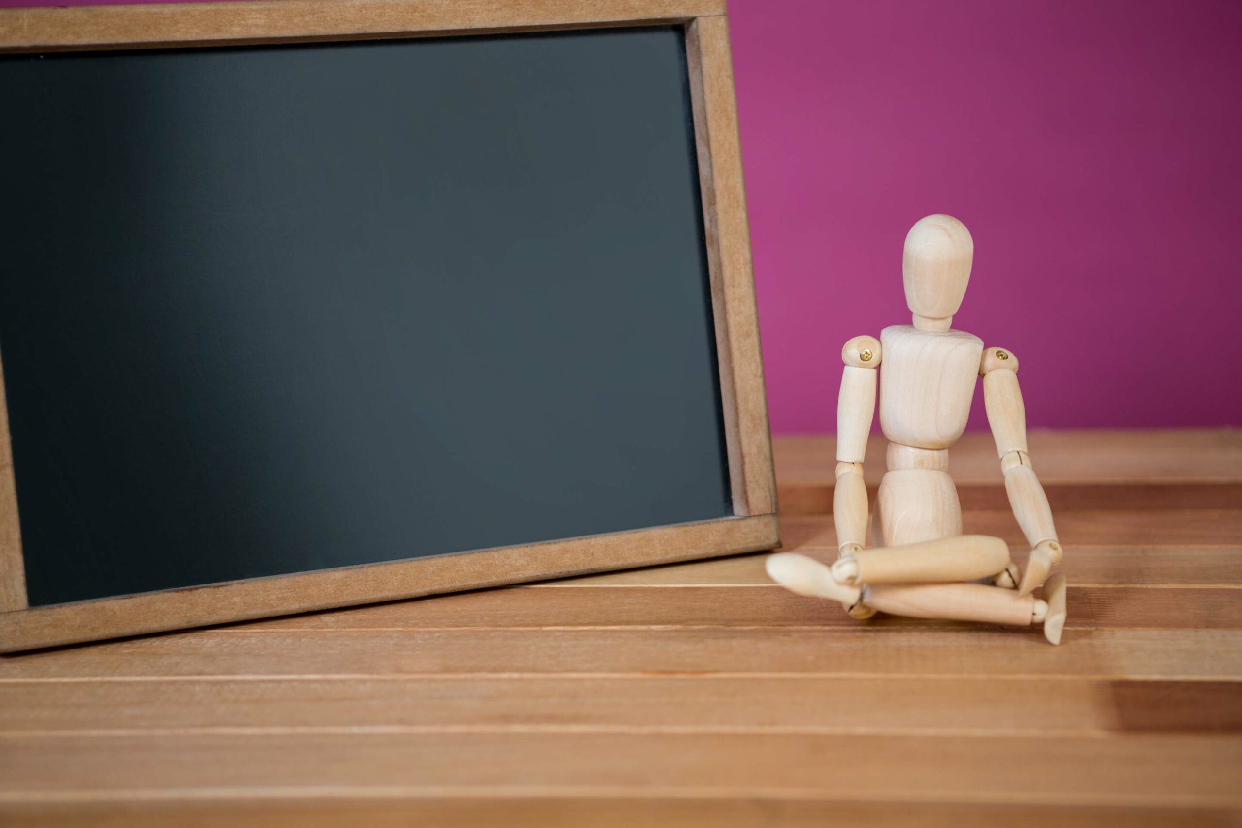 un mannequin en bois devant une ardoise vide dans un lycée
