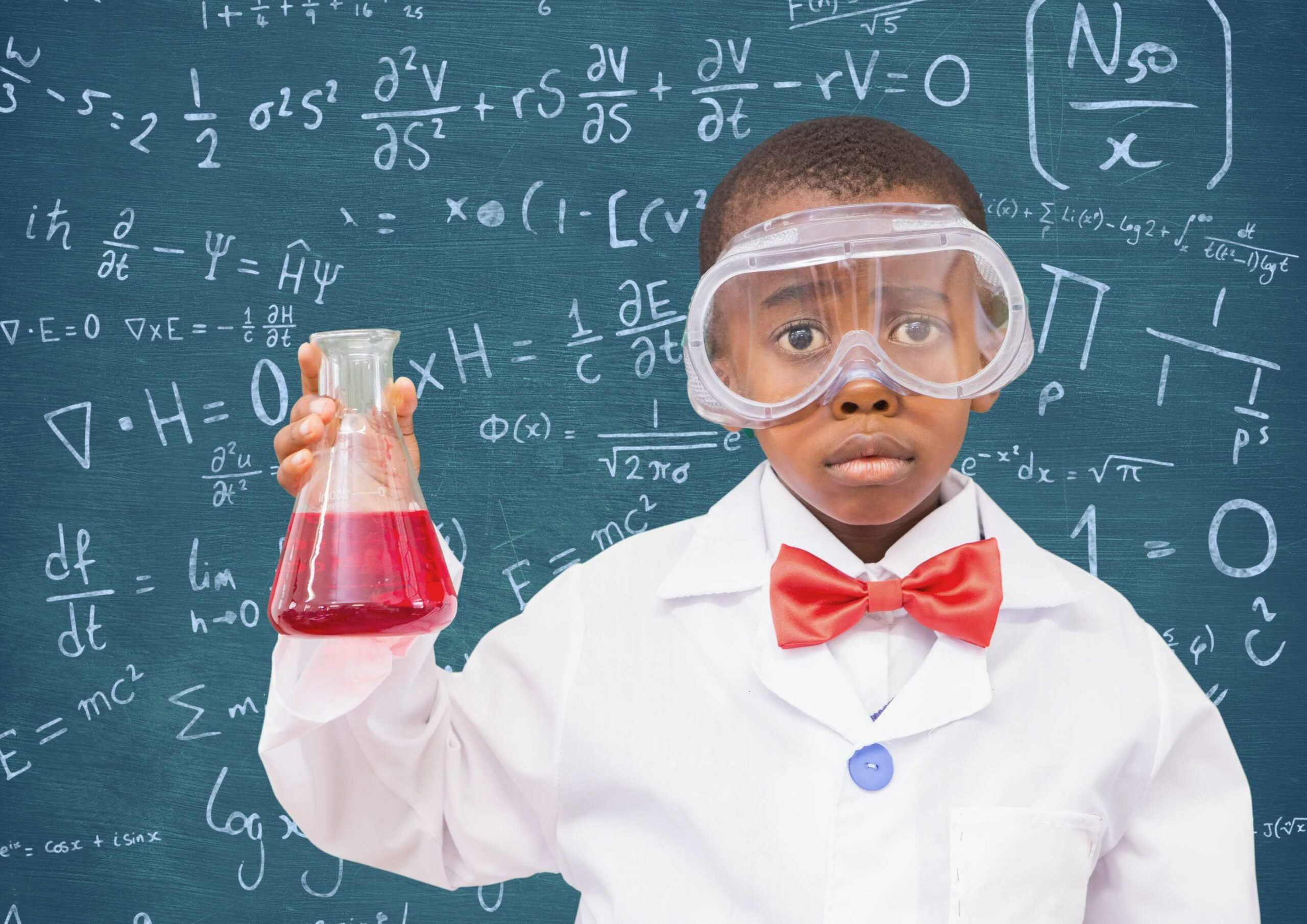 un jeune garçon en tenue de scientifique devant un tableau avec des formules mathématiques
